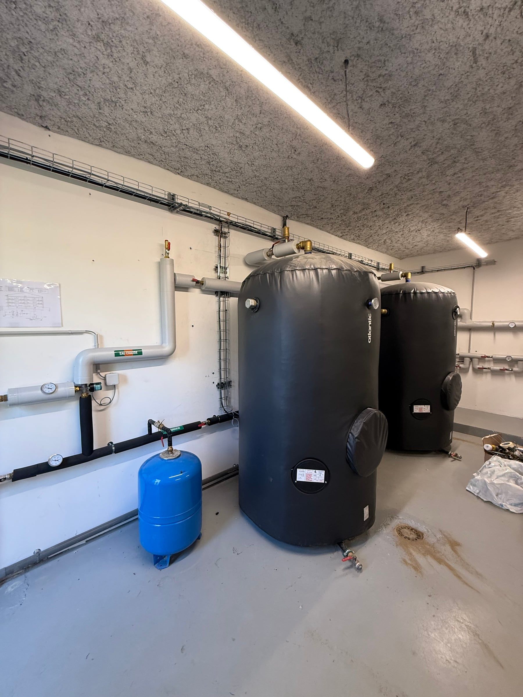 Deux grands ballons d’eau chaude sanitaire calorifugés dans une chaufferie collective